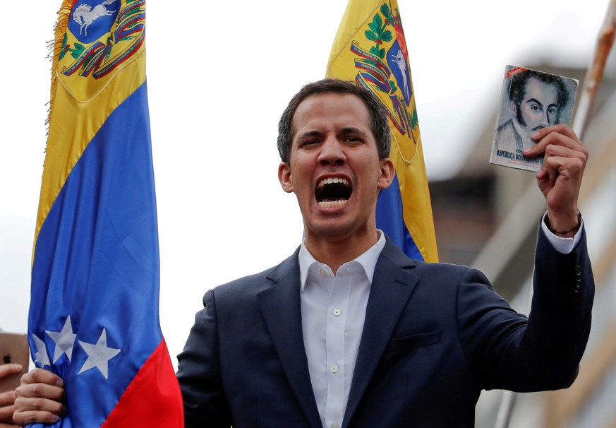 FILE PHOTO: Juan Guaido, President of Venezuela's National Assembly, holds a copy of Venezuelan constitution during a rally against Venezuelan President Nicolas Maduro's government and to commemorate  ...