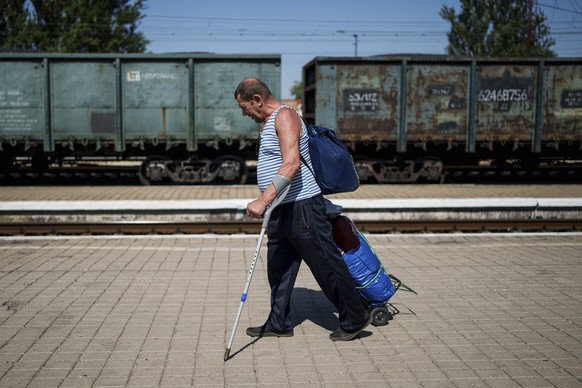 ARCHIV - 19.08.2024, Ukraine, Pokrowsk: Ein Mann zieht sein Gepäck auf einem Bahnsteig während der Evakuierung. Aufgrund des Vormarschs der russischen Truppen trifft der Krieg immer mehr neue Siedlung ...