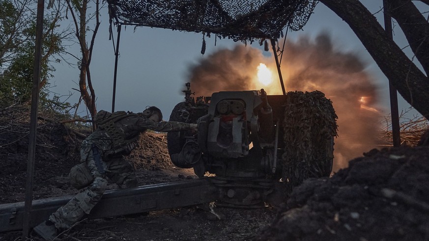 05.07.2023, Ukraine, Bachmut: Ein ukrainischer Soldat der 10. Sturmbrigade Edelweiß feuert die Munition einer D-30-Haubitze auf russische Stellungen an der Frontlinie. Foto: Libkos/AP/dpa +++ dpa-Bild ...