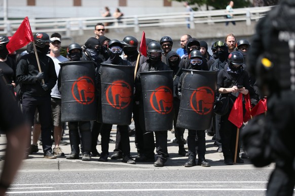 Protesters line up Saturday, Aug. 4, 2018, in Portland, Ore. Small scuffles broke out Saturday as police in Portland, Oregon, deployed &quot;flash bang&quot; devices and other means to disperse hundre ...