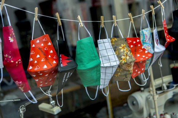 Selbst genähte Masken hängen während der Coronapandemie in einem Schaufenster in Bonn.