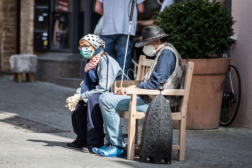 Zwei ältere Menschen sitzen in Tübingen auf einer Bank.