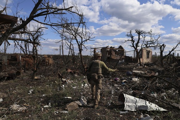 dpatopbilder - 16.09.2023, Ukraine, Andriivka: Ein Soldat zeigt auf ein zerstörtes Haus an der Frontlinie. Die Brigade gab bekannt, dass sie die vom Krieg zerstörte Siedlung, die 10 Kilometer südlich  ...
