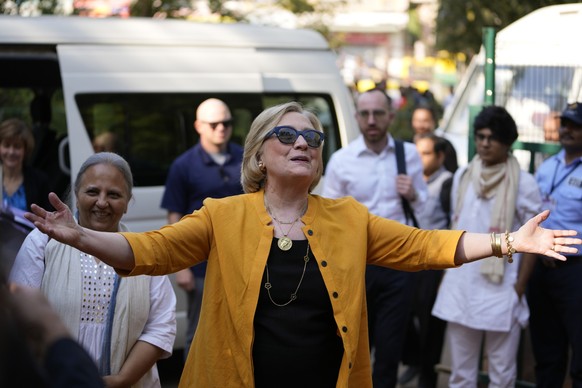 05.02.2023, Indien, Ahmedabad: Hillary Clinton, ehemalige Außenministerin der USA, gestikuliert bei ihrer Ankunft im Zentrum der Self Employed Women&#039;s Association (SEWA). Clinton ist zu einem zwe ...