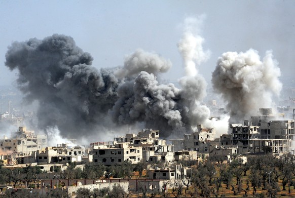 Rauch steigt nach dem Einschlag einer Rakete der syrischen Armee über Duma auf.&nbsp;