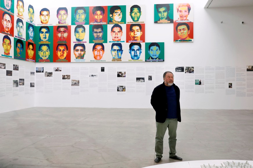 Chinese artist Ai Weiwei poses for photographers in front of portraits of the 43 missing Ayotzinapa College Raul Isidro Burgos students during a photocall for his exhibition &quot;Restablecer Memorias ...
