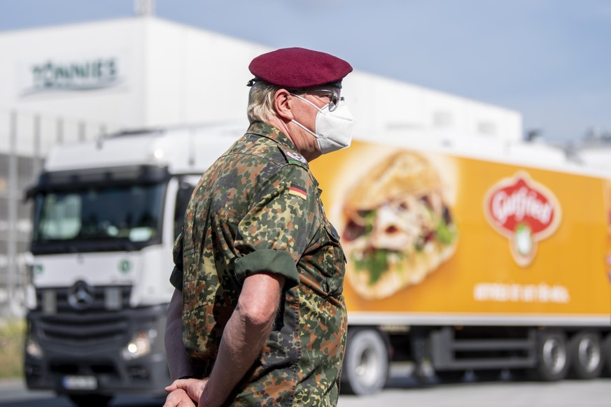 19.06.2020, Nordrhein-Westfalen, Rheda-Wiedenbrück: Ein Soldat der Bundeswehr steht vor dem Gebäude der Fleischfabrik Tönnies. Die Bundeswehr soll bei dem Testverfahren der Mitarbeiter auf den Coronav ...