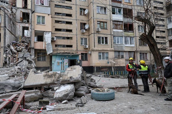 02.03.2024, Ukraine, Odessa: Hundef�hrer stehen neben einem Wohnhaus, das von einer russischen Drohne zerst�rt wurde. In der Nacht sind mehrere russische Dronen in Odessa eingeschlagen. Mindestens vie ...