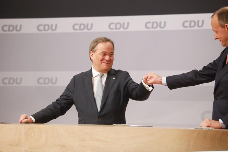 The new elected Christian Democratic Union, CDU, party chairman Armin Laschet, left, greets the other candidate of the final voting Friedrich Merz, right, after the voting at a digital party conventio ...