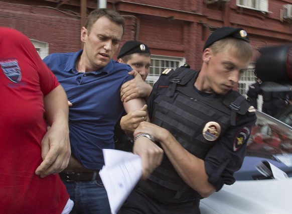 ARCHIV - 16.07.2013, Russland, Moskau: Polizeibeamte halten den russischen Oppositionsführer Alexej Nawalny (l) fest. Der russische Oppositionspolitiker Alexej Nawalny ist nach Angaben der Justiz in H ...