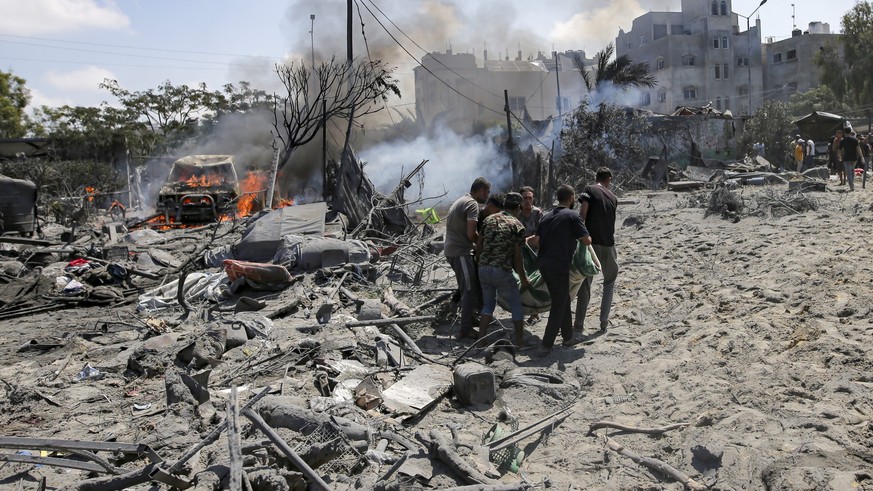 FILE - Palestinians evacuate a body from a site hit by an Israeli bombardment on Khan Younis, southern Gaza Strip, on July 13, 2024. Israel said it targeted Hamas&#039; military commander Mohammed Dei ...