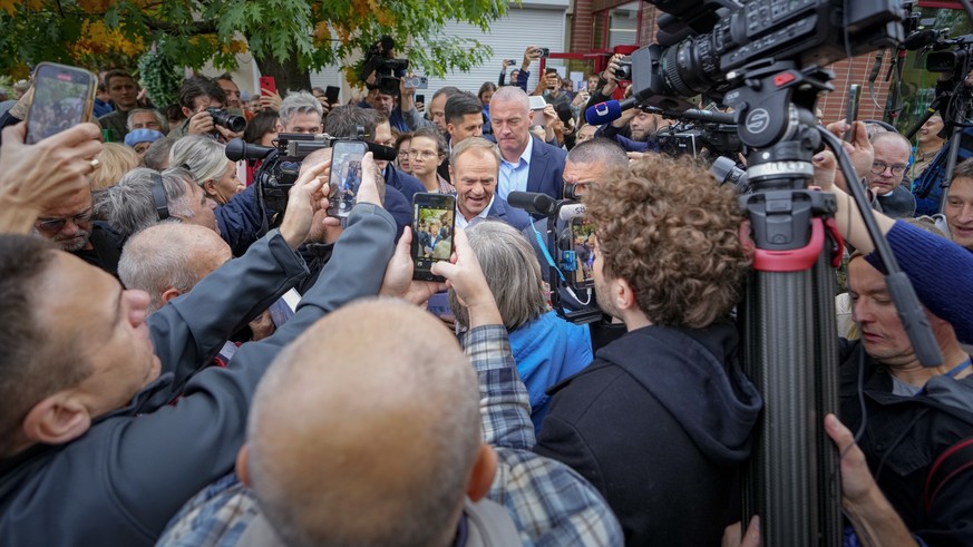 15.10.2023, Polen, Warschau: Donald Tusk (M), Oppositionsführer von Polen, spricht zu den Medien nach der Stimmabgabe bei den Parlamentswahlen. In Polen hat die Parlamentswahl begonnen. Foto: Petr Dav ...