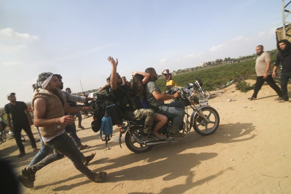 Hamas militants transport an Israeli woman taken from a kibbutz into the Gaza Strip on Saturday, Oct. 7, 2023. Hamas militants stormed the border with Israel, killed over 1,200 Israelis, and took more ...