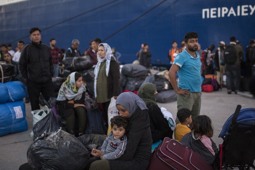 Flüchtlinge und Migranten in Piräus verlassen im Hafen eine Fähre.
