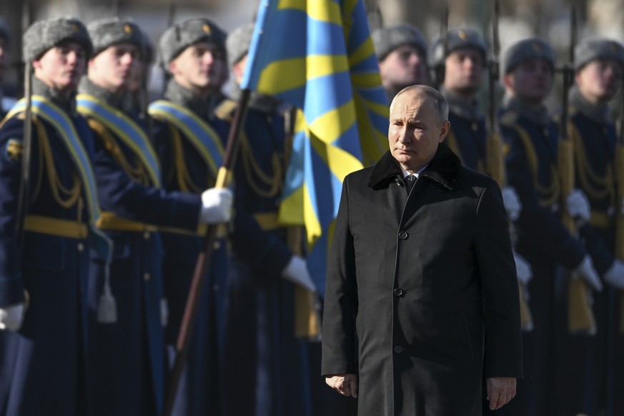 Russian President Vladimir Putin, foreground, attends a wreath-laying ceremony at the Tomb of the Unknown Soldier, near the Kremlin Wall during the national celebrations of the &quot;Defender of the F ...