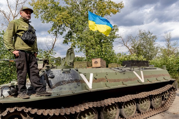 Region Charkiw: Ein ukrainischer Soldat steht auf einem beschlagnahmten russischen Panzer.