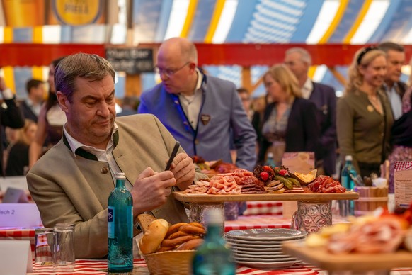 N�rnberg Fr�hlingsvolksfest 2024 - Bieranstich Ministerpr�sident Markus S�der CSU beim Bieranstich im Festzelt Papert vor einer Brotzeitplatte. beim pr�fen seiner Nachrichten auf seinem Mobiltelefon.  ...