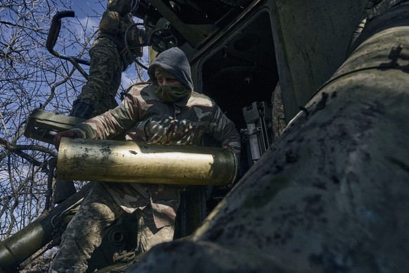05.03.2023, Ukraine, Bachmut: Ukrainische Soldaten bereiten sich auf den Abschuss einer Panzerhaubitze auf russische Stellungen in der Nähe von Bachmut vor. Foto: LIBKOS/AP/dpa +++ dpa-Bildfunk +++