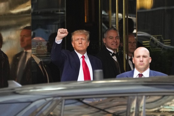 Donald Trump raises his fist as he leaves the courthouse in New York.