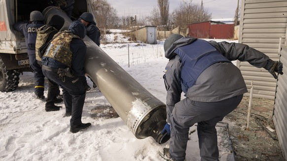 17.02.2023, Ukraine, Charkiw: Ukrainische Rettungskräfte schieben die Überreste einer abgefeuerten S-300-Rakete auf einen Lastwagen. Laut Angaben der Ukraine hat Russland die Ukraine mit einem Sperrfe ...