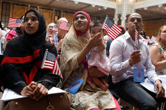 New citizens sit during a U.S. Citizenship and Immigration Services (USCIS) naturalization ceremony at the New York Public Library in Manhattan, New York, U.S., July 3, 2018. REUTERS/Shannon Stapleton