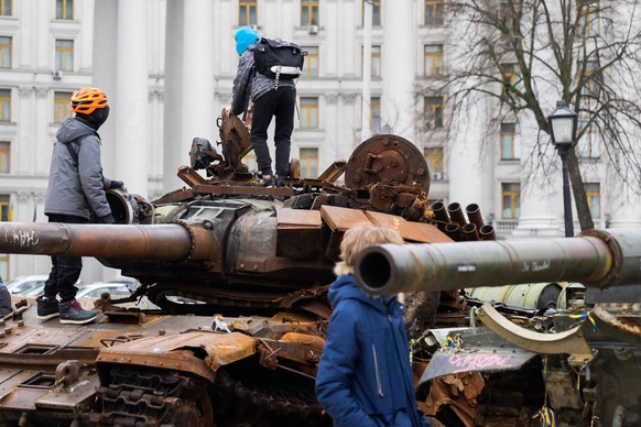 04.04.2023, Ukraine, Kiew: Kinder klettern auf einem zerstörten russischen Panzer in der Innenstadt. Bundeswirtschaftsminister Habeck ist mit einer Wirtschaftsdelegation zu Besuch in der Ukraine. Foto ...