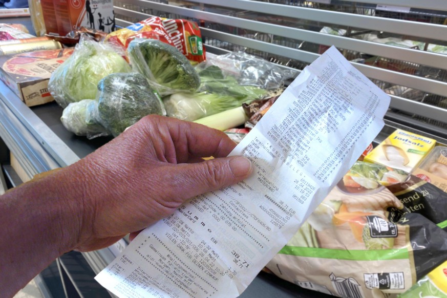 FOTOMONTAGE: Einkaufen immer teurer!Ein Blick auf den Kassenbon loest bei den Verbrauchern Entsetzen aus. Lebenshaltungskosten in Deutschland auf Rekordhoch. Waren,Gueter,Lebensmittel liegen auf einem ...