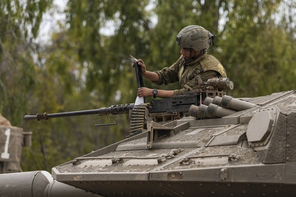 An Israeli soldier works on a tank at a staging ground near the Israeli Gaza border, southern Israel, Monday, Oct. 9, 2023. The militant Hamas rulers of the Gaza Strip carried out an unprecedented, mu ...