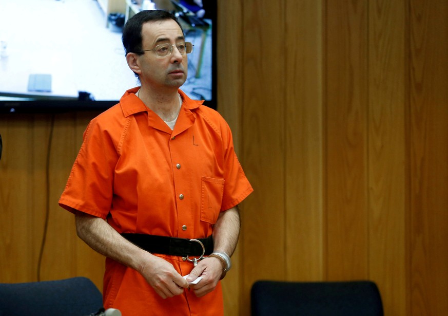 FILE PHOTO: Larry Nassar, a former team USA Gymnastics doctor who pleaded guilty in November 2017 to sexual assault charges, stands in court during his sentencing hearing in the Eaton County Court in  ...