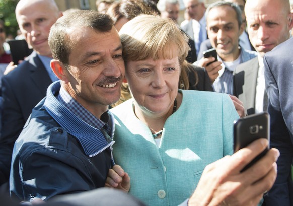 FILE - This Sept. 10, 2015 file photo shows German Chancellor Angela Merkel taking a selfie with a refugee at the refugee reception center in Berlin, Germany. Angela Merkel faces a race against time t ...