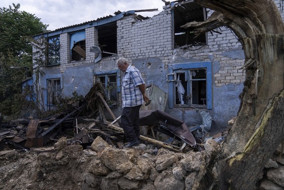 29.06.2023, Ukraine, Cherson: Ein Einheimischer geht vor einem durch russischen Beschuss beschädigten Gebäude in Cherson. In der südukrainischen Stadt Cherson sind am 29.06.2023 nach Angaben lokaler B ...