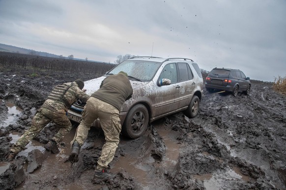 19.11.2022, Bakhmut area. Ukrainians in the Bakhmut area. The conditions are getting harder as the winter looms. On the photo men pushing a car that is stuck in mud. Photo: Erik Prozes, Postimees Done ...