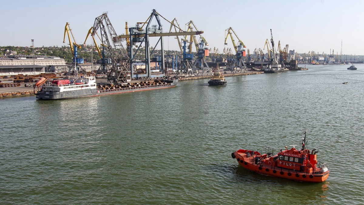 30.05.2022, Ukraine, Mariupol: Ein russisches Schiff, oben links, bereitet sich auf die Abfahrt aus dem Seehafen von Mariupol vor. Es war das erste Mal seit Beginn des Krieges in der Ukraine, dass ein ...