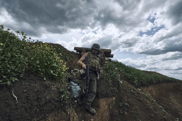 A Ukrainian soldier is seen in a trench at the frontline near Bakhmut in the Donetsk region, Ukraine, Monday, May 22, 2023. (AP Photo/Libkos)