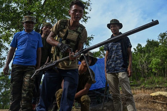 In this picture taken on July 24, 2023, an armed man claiming to be a volunteer demonstrates working of a weapon at a makeshift camp on a hilltop at Churachandpur district, stronghold of the Kuki trib ...
