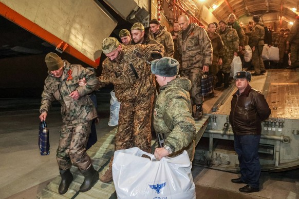 RUSSIA, MOSCOW REGION - APRIL 10, 2023: Russian soldiers, released from captivity after a prisoner swap with Ukraine, disembark from their plane after landing. All 106 of them are entitled to medical  ...