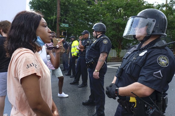 Protesters stand in front of police Sunday, June 14, 2020, in Atlanta. Rayshard Brooks, 27, was fatally shot by an Atlanta police officer Friday night. (Ben Gray/Atlanta Journal-Constitution via AP)
