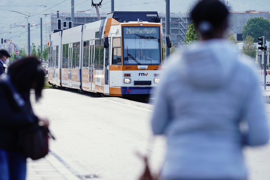 Menschen warten an einer Straßenbahnhaltestelle auf die Ankunft einer Straßenbahn. Viele Menschen haben die testweise eingeführten Gratisfahrten in Bussen und Straßenbahnen in Heidelberg an den vergan ...