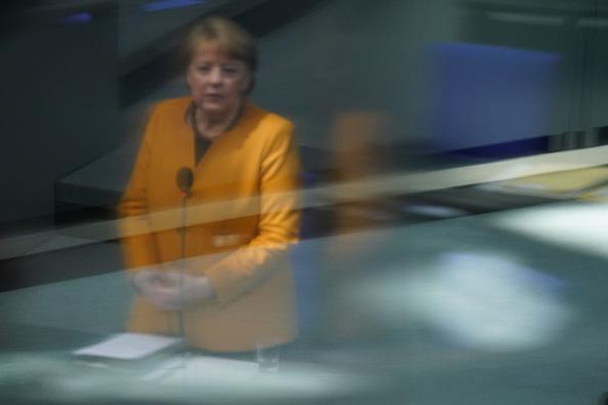 BERLIN, GERMANY - MARCH 24: German Chancellor Angela Merkel is reflected in glass as she takes questions from parliamentarians at the Bundestag after she announced a reversal of a hard lockdown for Ea ...