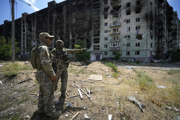 Sewerodonetsk, Ukraine: Russische Soldaten vor einem zerstörten Haus.