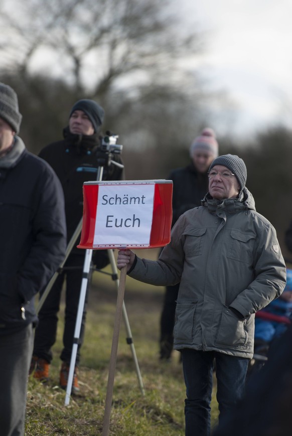 Demonstration gegen Enteignung von Bauer Knop Demonstrant haelt Schneeschaufel vor, wo ein Stueck Papier befestigt ist mit der Aufschrift Schaemt euch , am 24.02.2018 in Flensburg Tarup *** Demonstrat ...