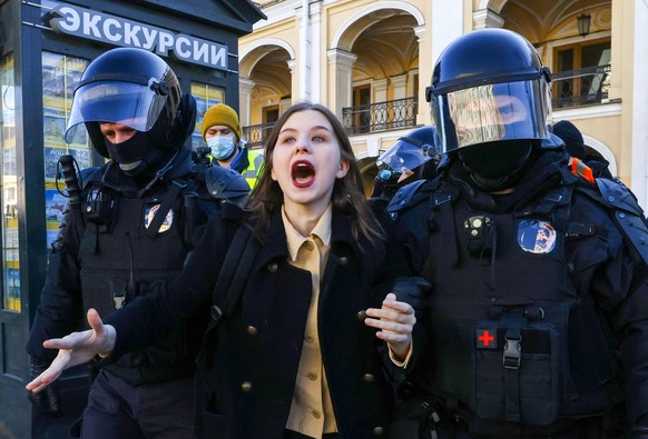 ST PETERSBURG, RUSSIA - MARCH 13, 2022: Law enforcement officers detain a woman during an unauthorized rally against Russia s special military operation in Ukraine. On February 24, Russia s President  ...