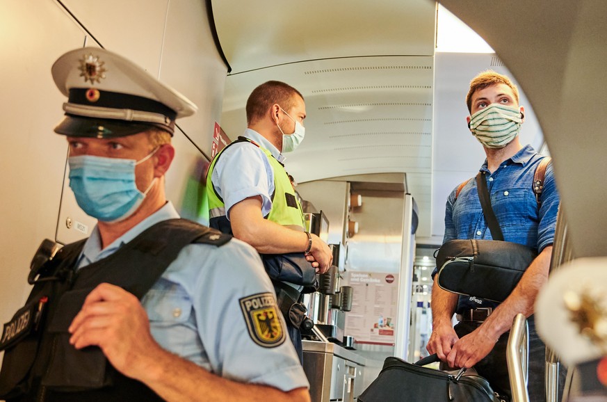 05.08.2020, Berlin: Beamte der Bundespolizei und Mitarbeiter der DB Sicherheit stehen in einem IC kurz vor dem Berliner Hauptbahnhof und kontrollieren, ob die coronabedingte Maskenpflicht eingehalten  ...