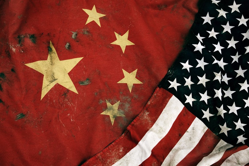 Low key photography of grungy old flags of China and USA.
