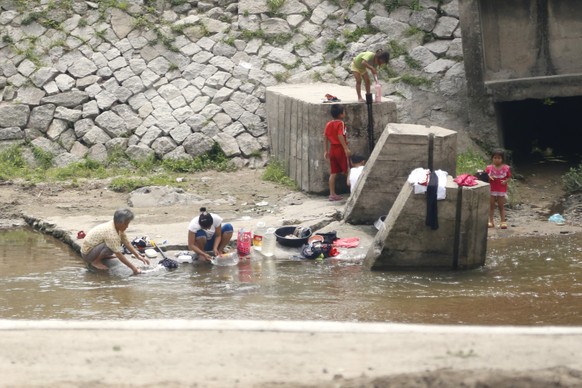 North Korean women wash clothes in a canal near the road in Kaesong, a city by DMZ (Korean De-militarized zone) in North Korea, DPRK.