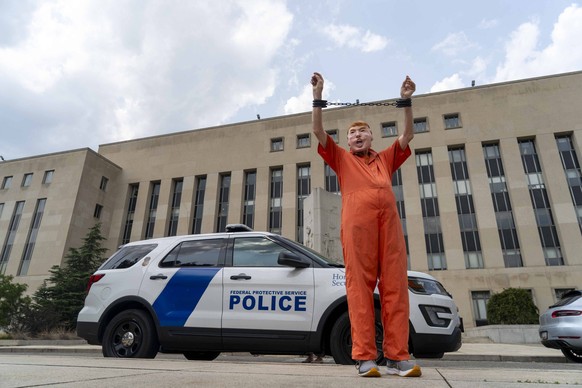 A demonstrator dressed as former president Donald Trump stands in fake handcuffs outside the E. Barrett Prettyman Federal Courthouse in Washington, DC on Wednesday, August 2, 2023 ahead of Donald Trum ...