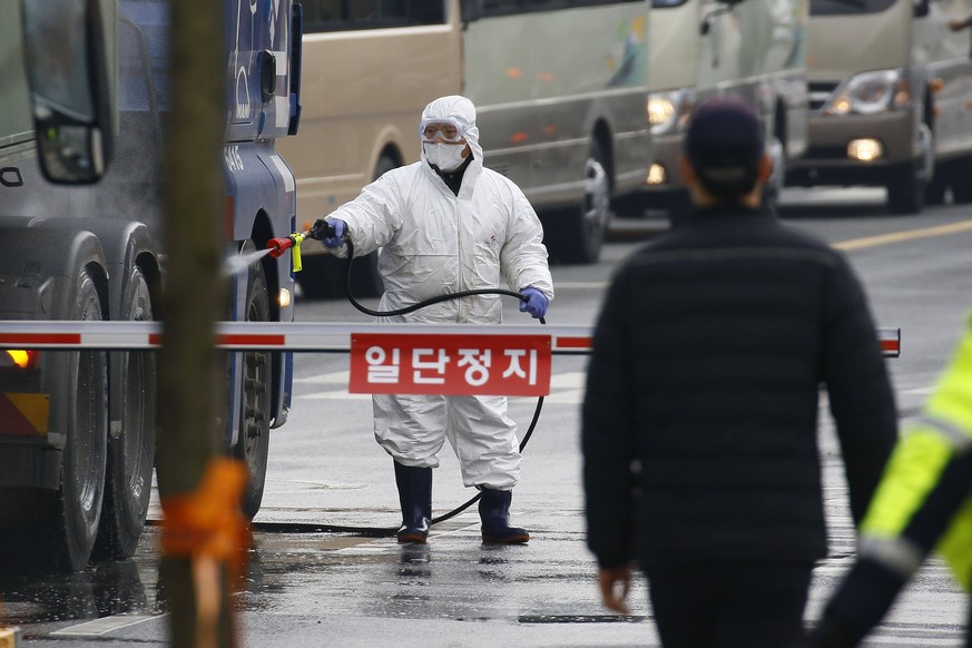 Im südkoreanischen Bezirk Jincheon desinfiziert ein Beamter die Reifen eines Lkw. 370 Heimkehrer aus der chinesischen Stadt Wuhan werden am Freitag am Flughafen Gimpo erwartet.