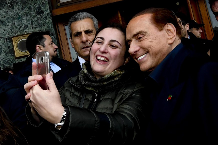 Italian former prime minister and leader of &#039;Forza Italia&#039; party Silvio Berlusconi poses for a selfie with a fan in front of the hotel Vesuvio in Naples, Italy, Saturday, March 3, 2018. Ital ...