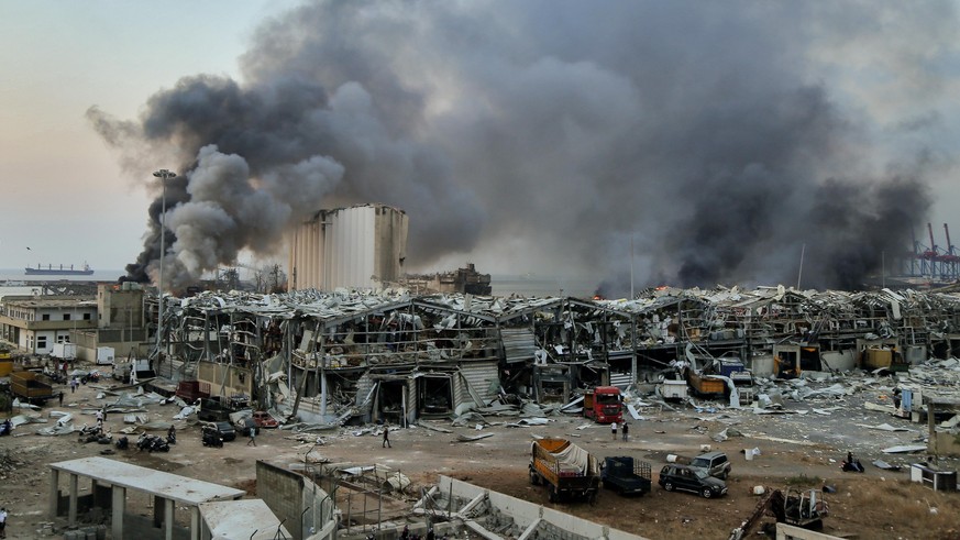 dpatopbilder - 08.01.2020, Libanon, Beirut: Rauch steigt nach einer Explosion über einem Gebäude am Hafen auf. Eine schwere Explosion erschüttert die Innenstadt von Beirut und beschädigte Gebäude. Es  ...