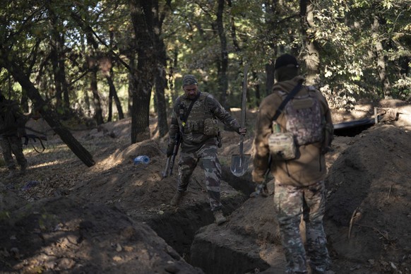 12.10.2022, Ukraine, Cherson: Ukrainische Soldaten �berpr�fen die von russischen Soldaten ausgehobenen Sch�tzengr�ben. Foto: Leo Correa/AP/dpa +++ dpa-Bildfunk +++